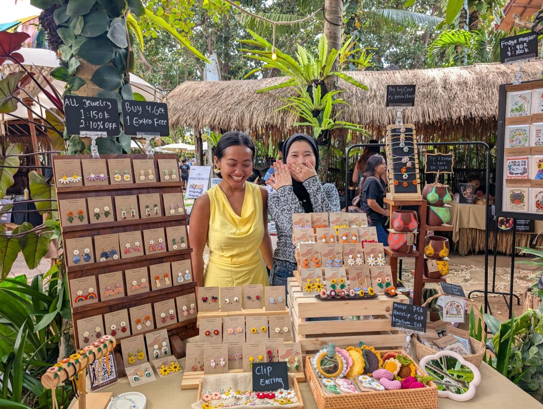 Two people smiling behind the Terra Flora Bali stall at La Brisa Sunday Market in Canggu