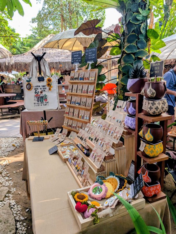 The Terra Flora Bali stall at La Brisa Sunday Market with earring racks, a tote bag and hand-painted plant pots