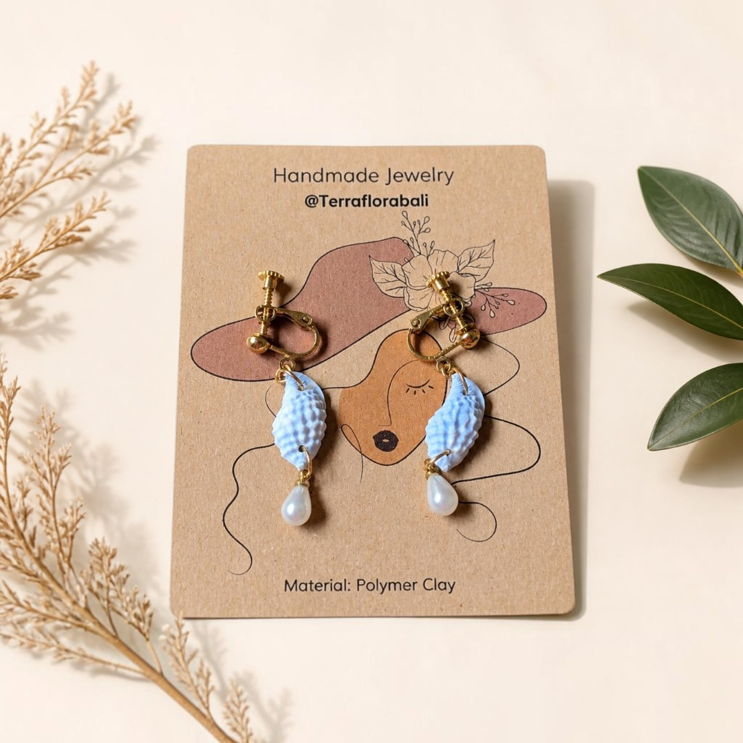 Close-up of gold screw-back clip-on fittings on a pair of baby blue polymer clay earrings for non-pierced ears